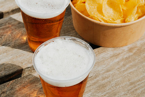 cups with beer and  potato chips on a dock, a Photo by Nito