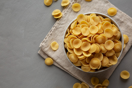 Dry, Uncooked Orecchiette Pasta in a Bowl, top view. Flat lay, o, a Food & Drink Photo by LiudmylaChuhunova