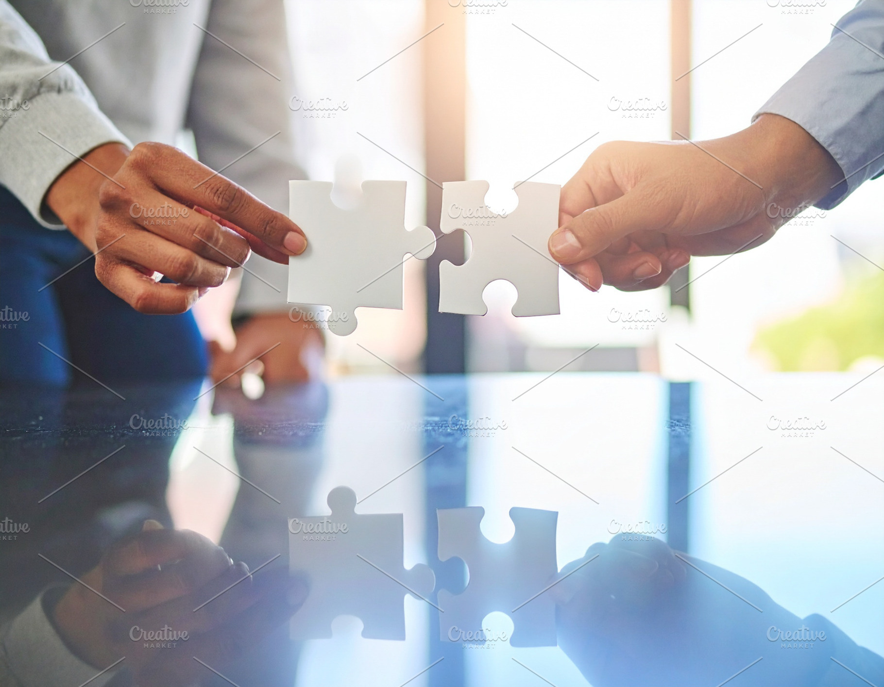 Two professional hand connecting two puzzle pieces on a desk, a Business Photo by DanFLCreativo