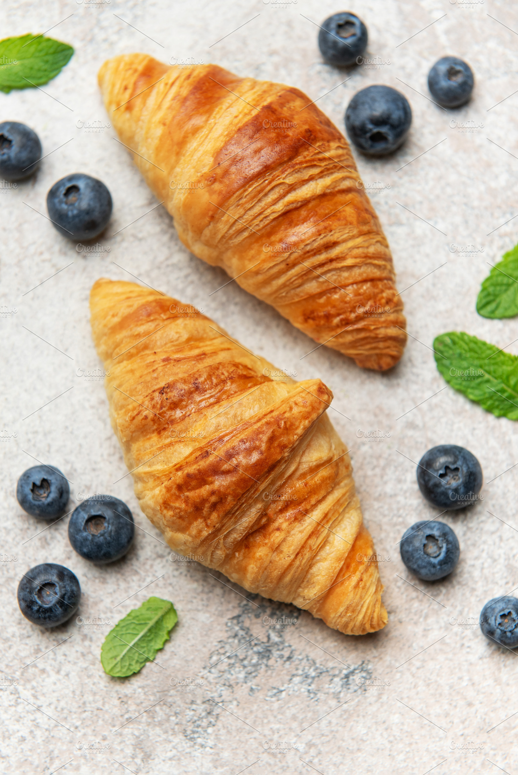 Delicious french croissants with fresh blueberries and mint on a, a Food & Drink Photo by Olena Rudo
