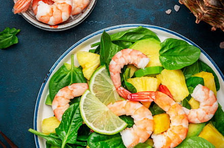 Fresh pineapple salad with shrimps, spinach, avocado and lime on, a Food & Drink Photo by 5PH