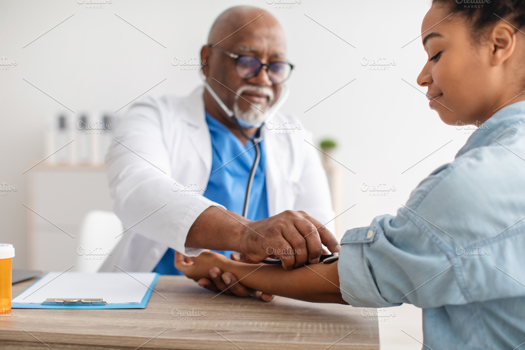 Black male doctor checking measuring pressure on patient's hand, a Photo by Prostock-Studio