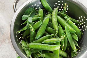 Fresh green peas pods in metal colander, a Food & Drink Photo by Olena Rudo