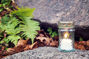 Candle standing on tombstone, a Nature Photo by BOOCYS