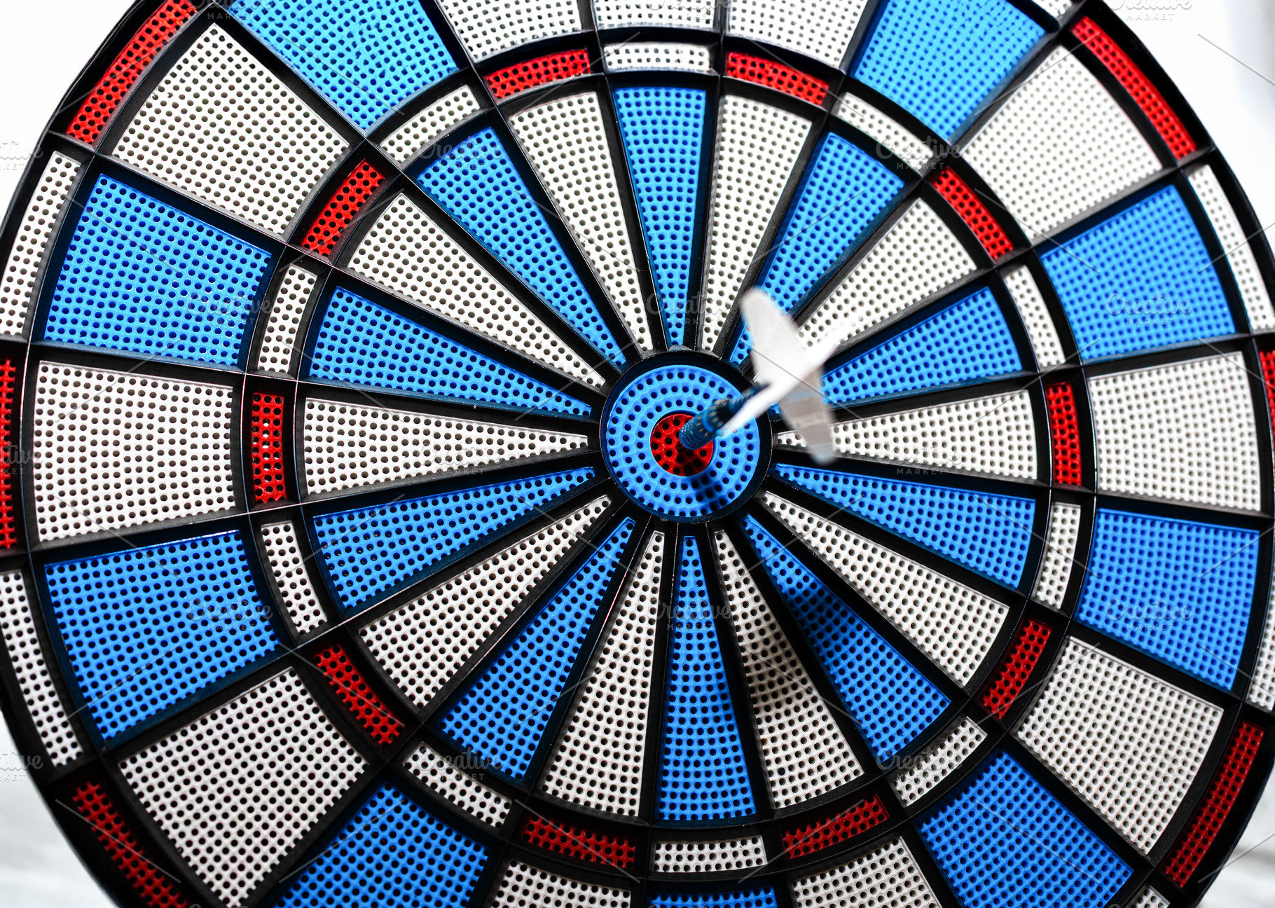 White dart striking the bullseye on a vibrant plastic dartboard, an Animal Photo by Ales Munt