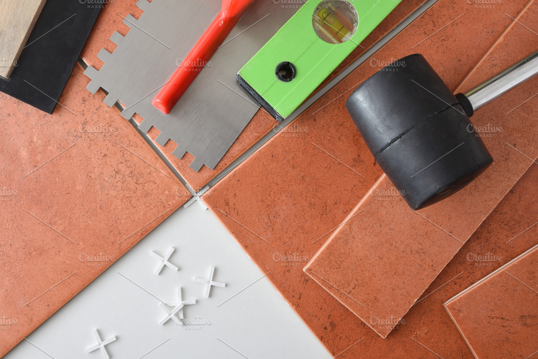 Laying tiles with spacers with tools on top, an Architecture Photo by Davizro's Market
