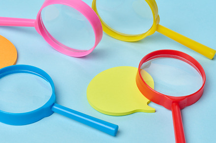 Multicolored plastic magnifying glasses on a blue background and, a Business Photo by ndanko