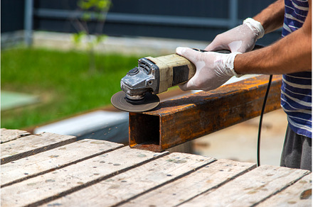 A man processes a metal pole, an Industrial Photo by yanadjana