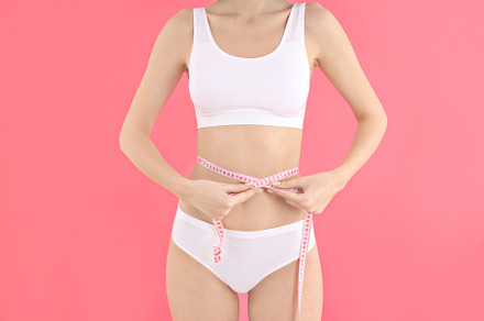 Concept of weight loss, young woman on pink background, a Person Photo by AtlasStudio