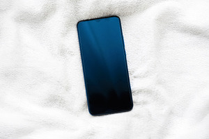 Smartphone resting on white fluffy blanket, representing modern communication,, a Photo by Studio ANNA