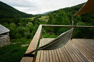 Wooden Deck with Hammock Overlooking Green Forest and Mountain Landscape, a Photo by AS photostudio