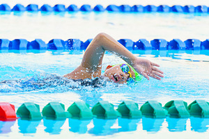 Swimmer child swims freestyle swimming style in a race swimming