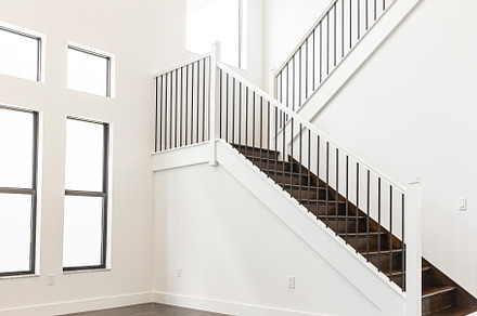 Modern white wooden staircase in new house interior with big windows