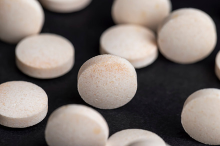 White and yellow medical medicines on a black background, a Background Photo by MyPhotos