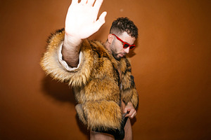 Wearing fur coat and red sunglasses with hand gesturing stop, a Photo by karrastock
