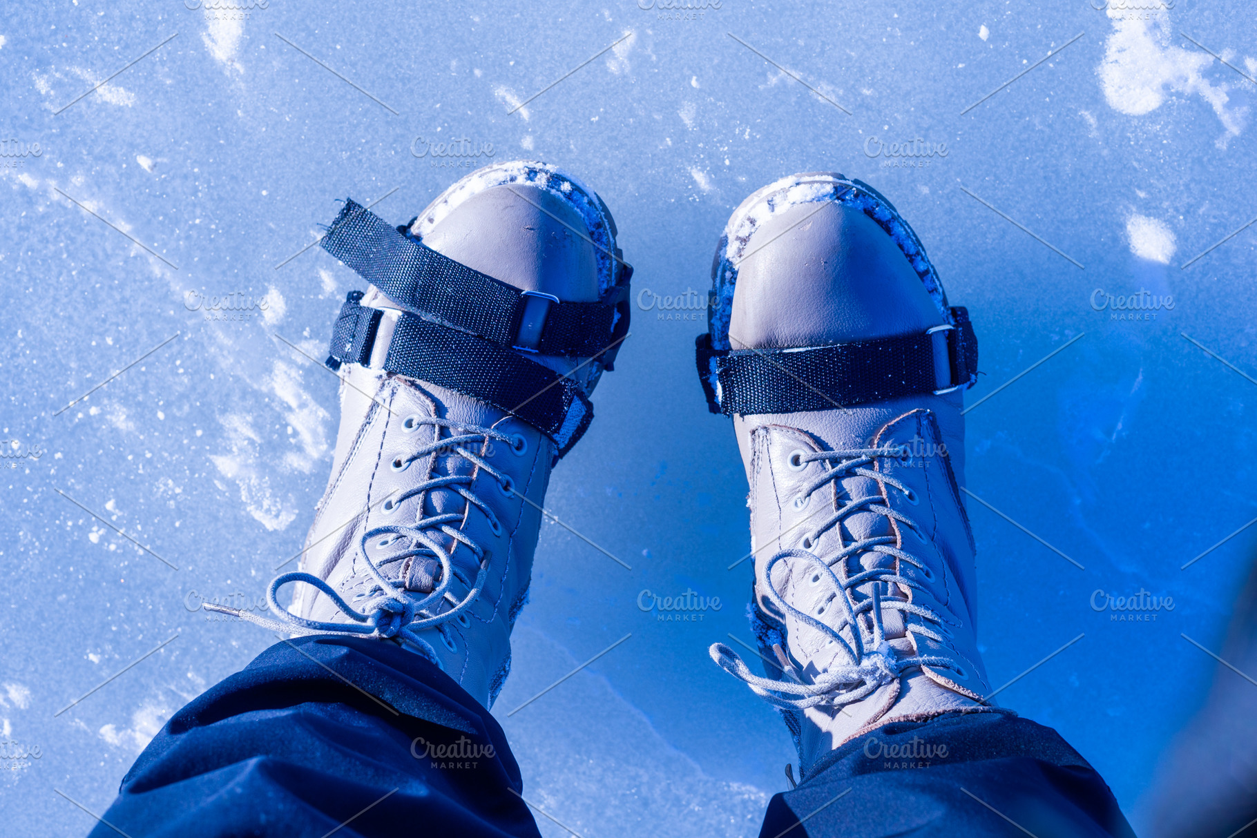 Top view of boots with ice cleats on frozen icy surface, a Photo by MDBildes
