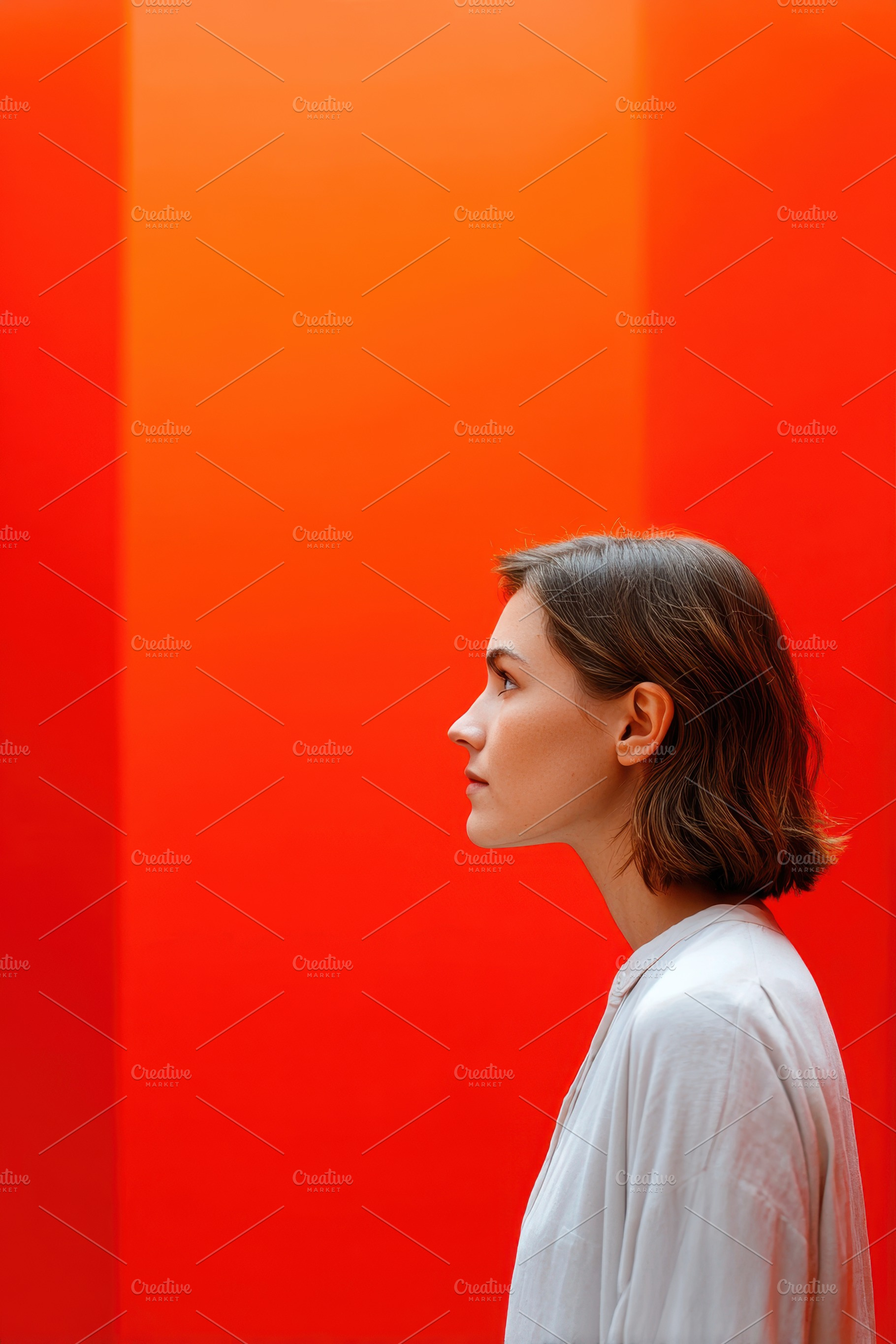 Profile portrait of a woman against an orange backdrop, a Person Photo by AlyaAnd