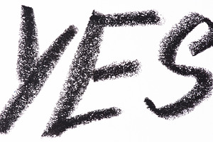 Word YES written in large, textured black crayon letters on a wh, an Abstract Photo by ndanko