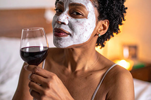 Woman with her face covered by a white facial mask while holding, a Health & Medical Photo by DanFLCreativo