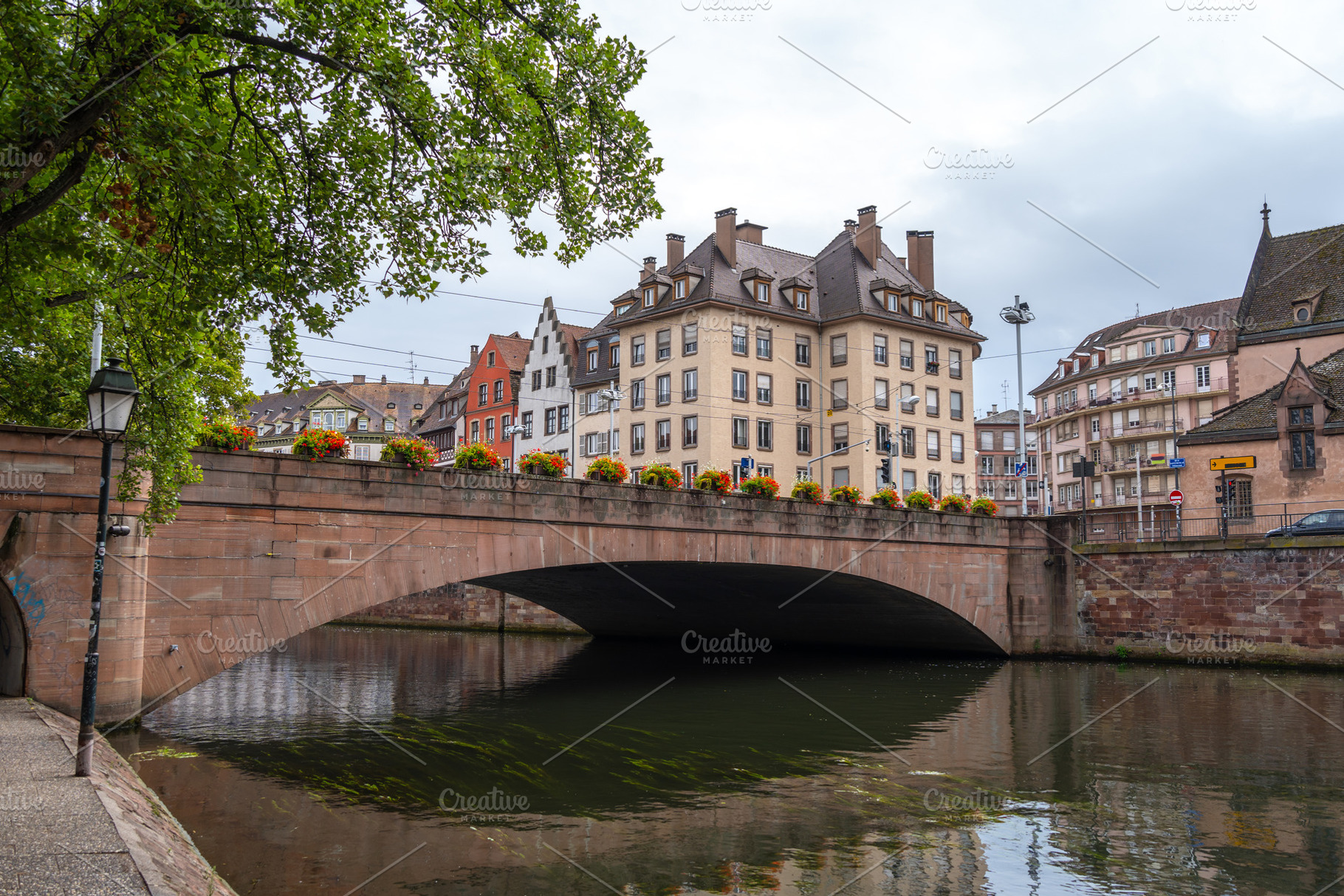 Stone bridge with flowers crossing the Ill river Strasbourg, Fra, an Architecture Photo by GoodGoods