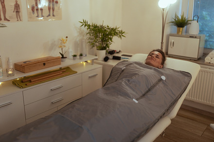 woman doing whiskey swaddling procedure in thermal blanket, a Health & Medical Photo by Alliance Images