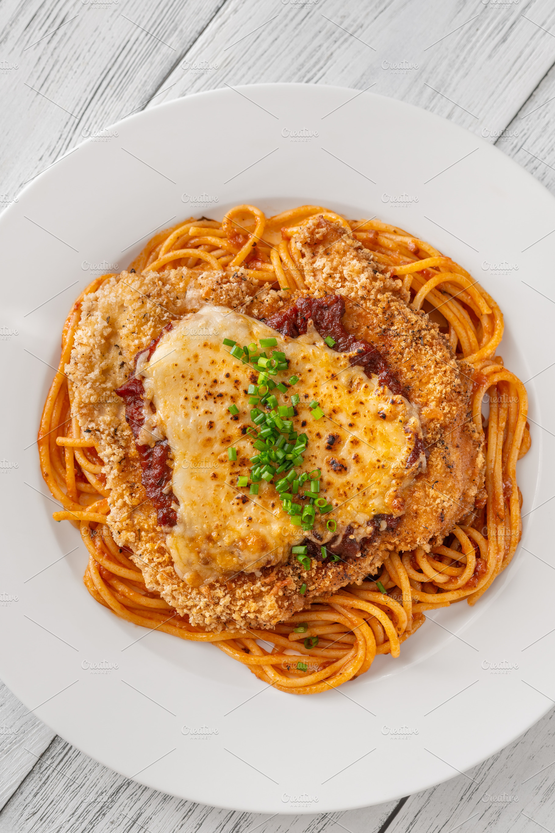 Crispy Chicken Parmesan served over, a Food & Drink Photo by Alexander Prokopenko