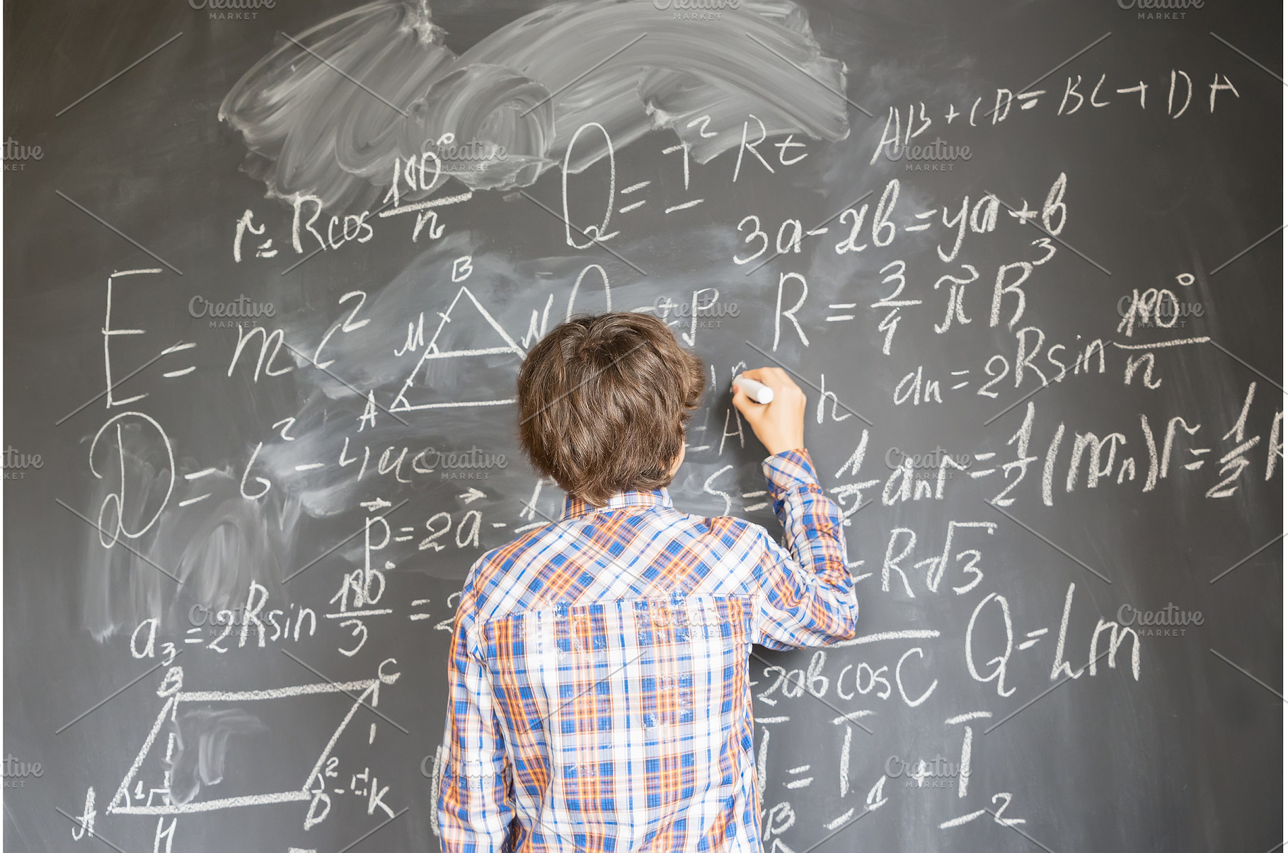 Boy writting on black board, a School & Education Photo by Neirfy