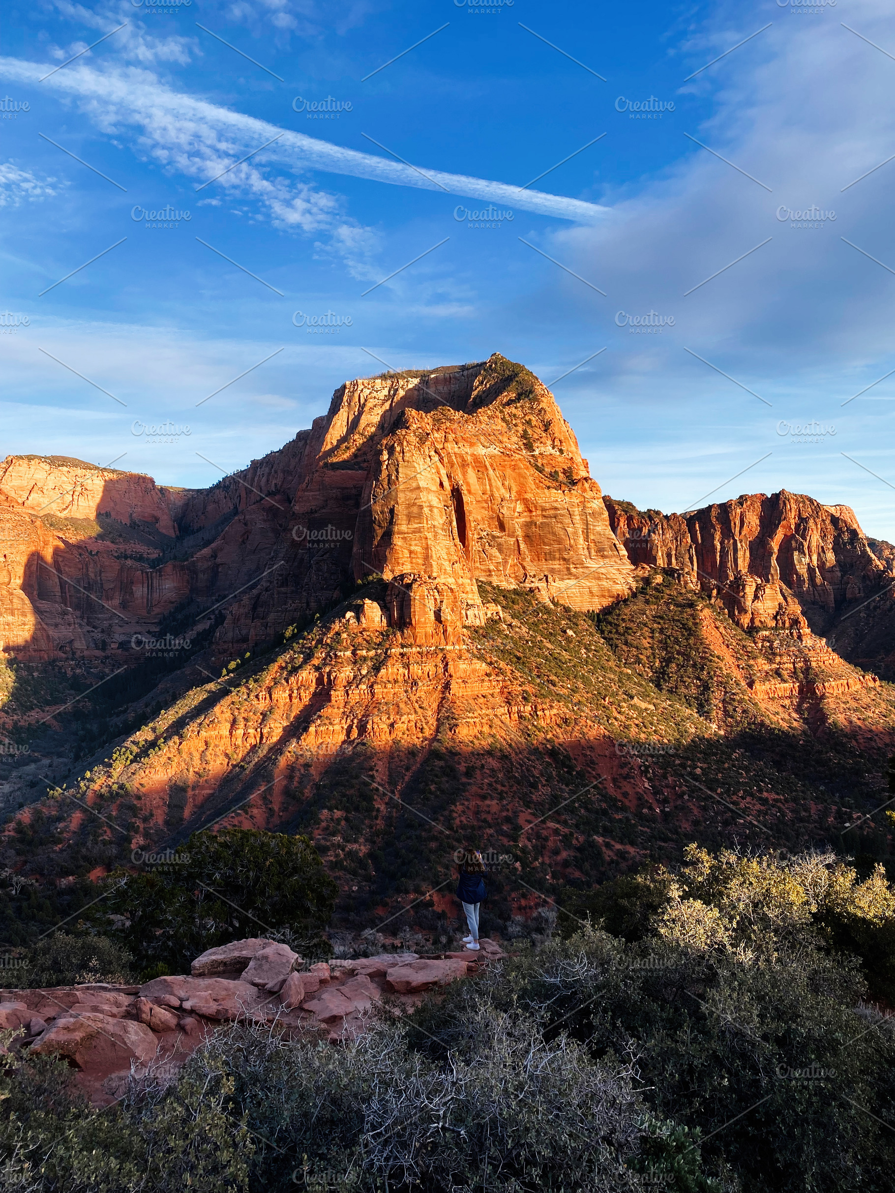 Hiker overlooking vast red rock canyon in Utah with blue sky and dramatic cliff, a Nature Photo by AS photostudio