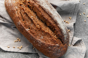 Rustic rye sourdough bread loaf on gray cloth, a Food & Drink Photo by Olena Rudo