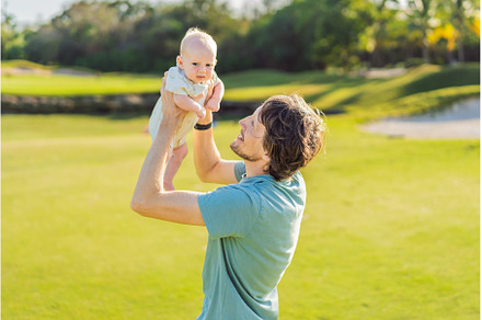 Father and newborn baby on a meadow
