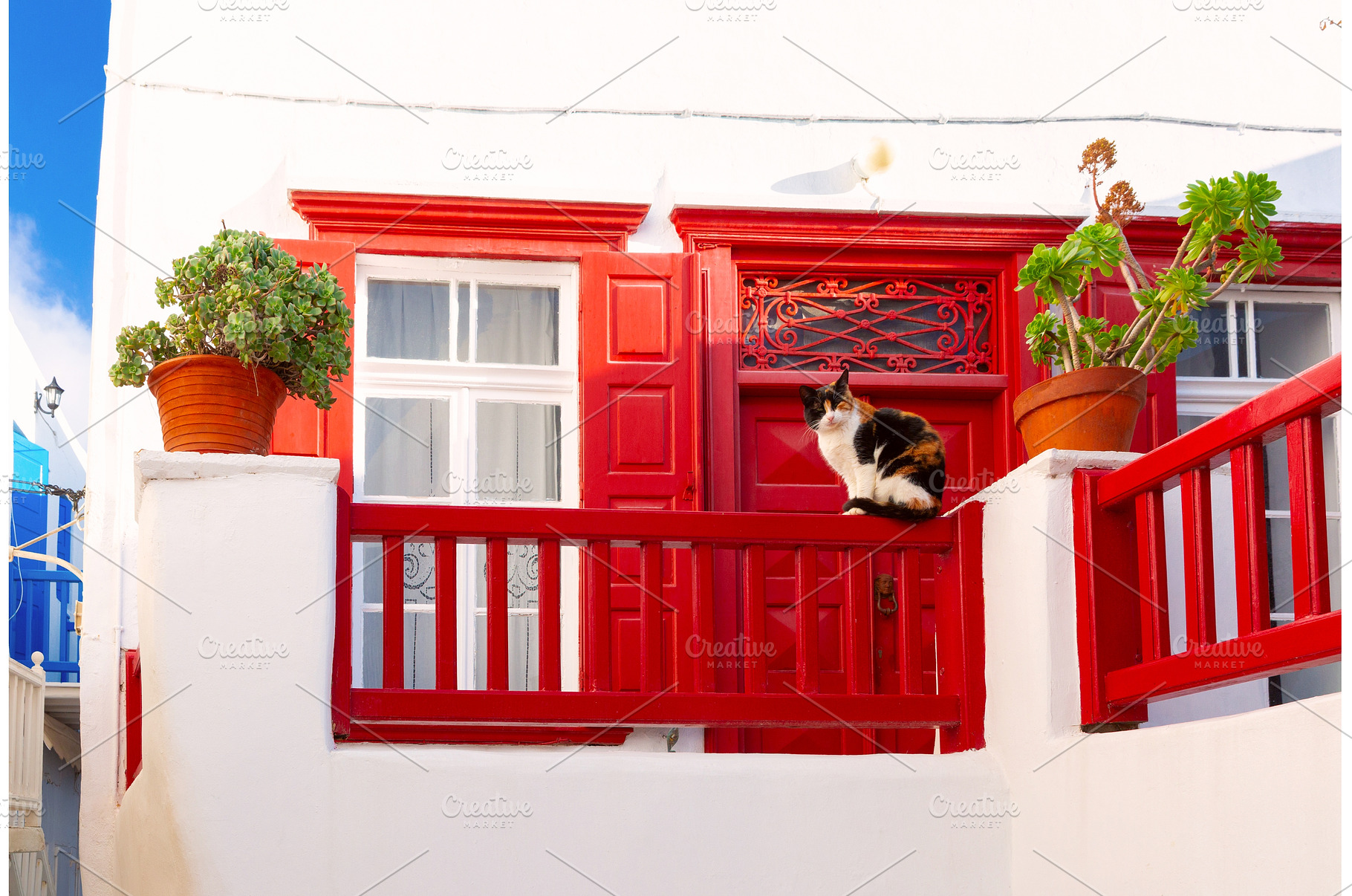 Cat on red balcony of white house in, an Architecture Photo by kavalenkava