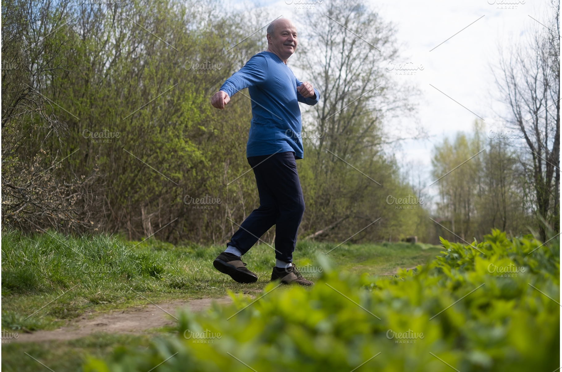 Active senior man is jogging in park, a Sports & Recreation Photo by Koldunova