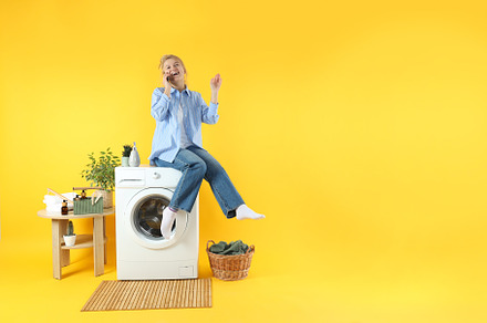 Concept of housework with washing machine and girl on yellow bac, a Person Photo by AtlasStudio PRO