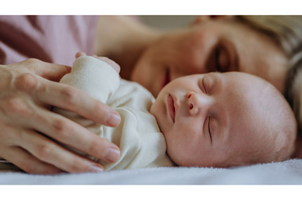 Mother cuddling with her newborn, a Person Photo by HalfPoint