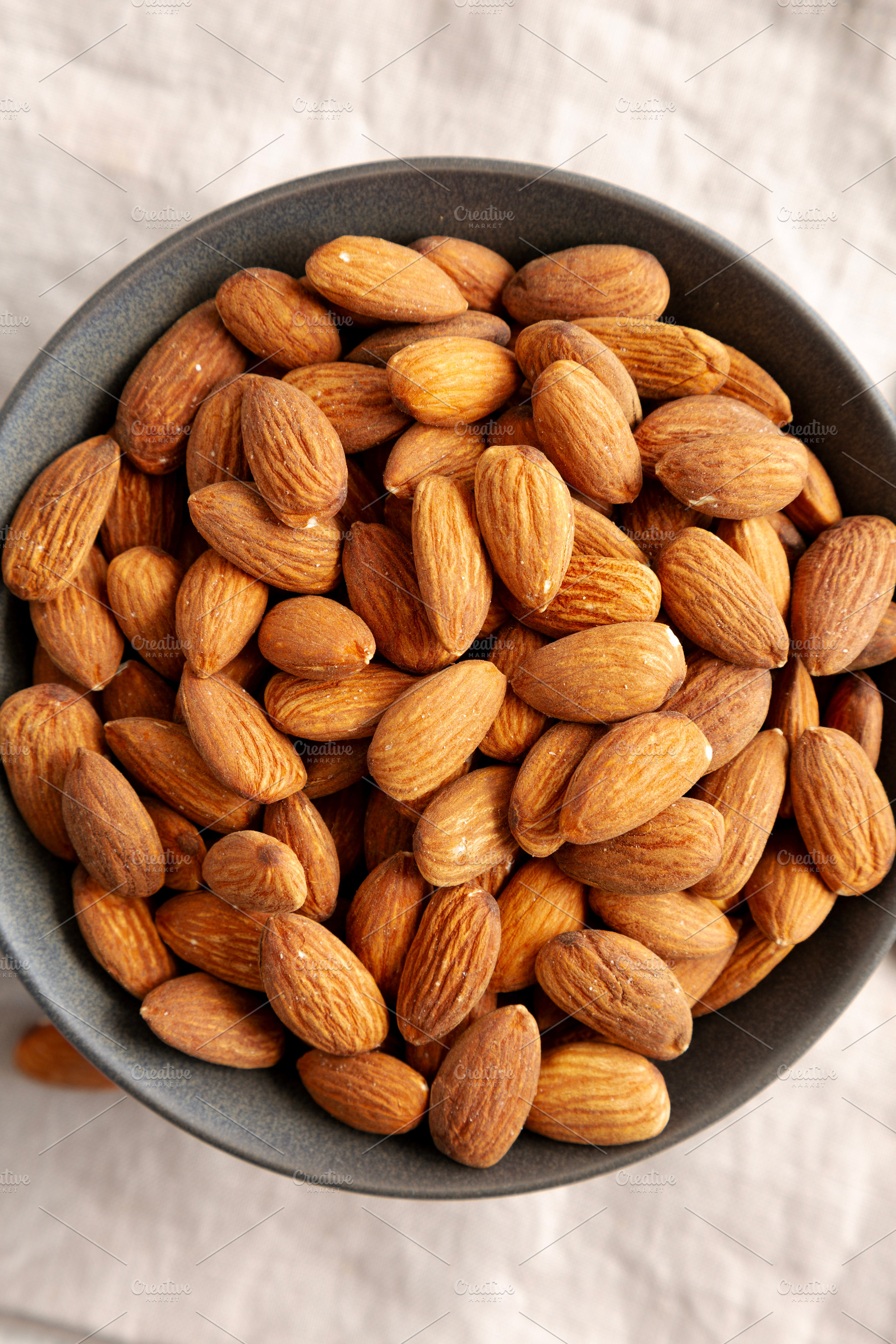 Roasted Almonds in a Bowl, top view. Flat lay, overhead, from ab, a Food & Drink Photo by LiudmylaChuhunova