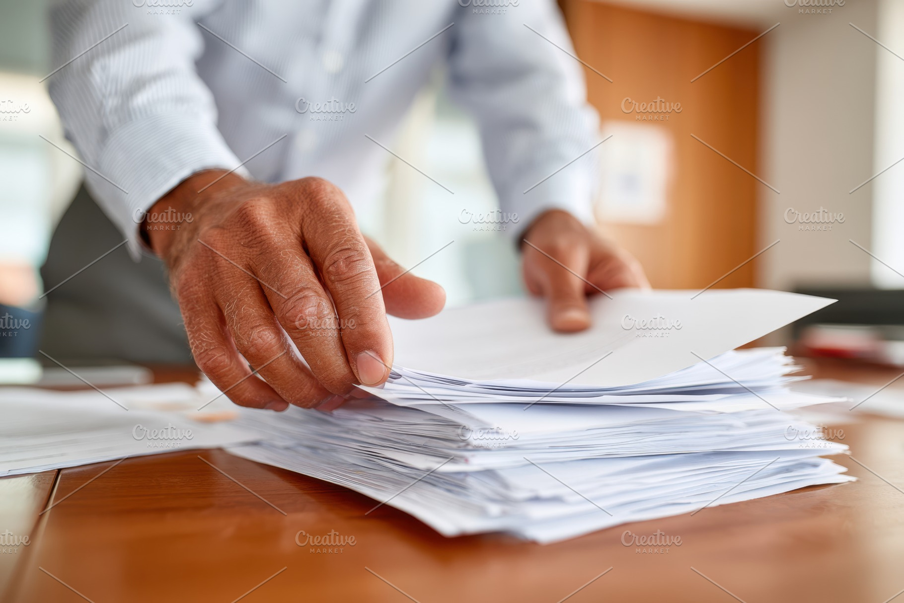 Sorting papers on a wooden desk in an office, a Business Photo by AlyaAnd
