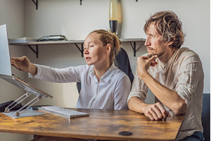 Man and woman working together in, a Person Photo by Elizaveta Galitskaya
