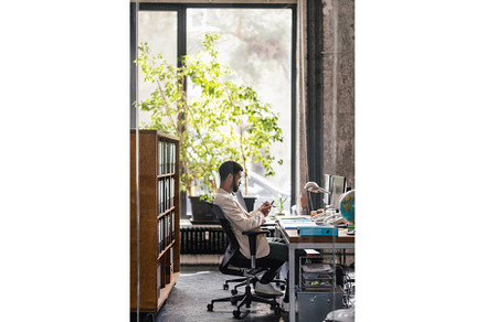 Young man sitting in office and, a Person Photo by HalfPoint