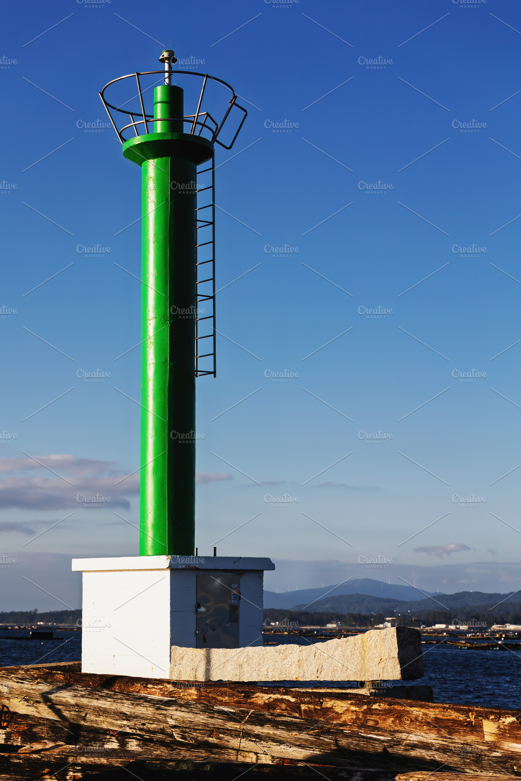 Green maritime beacon in a coastal p, an Industrial Photo by Perpis