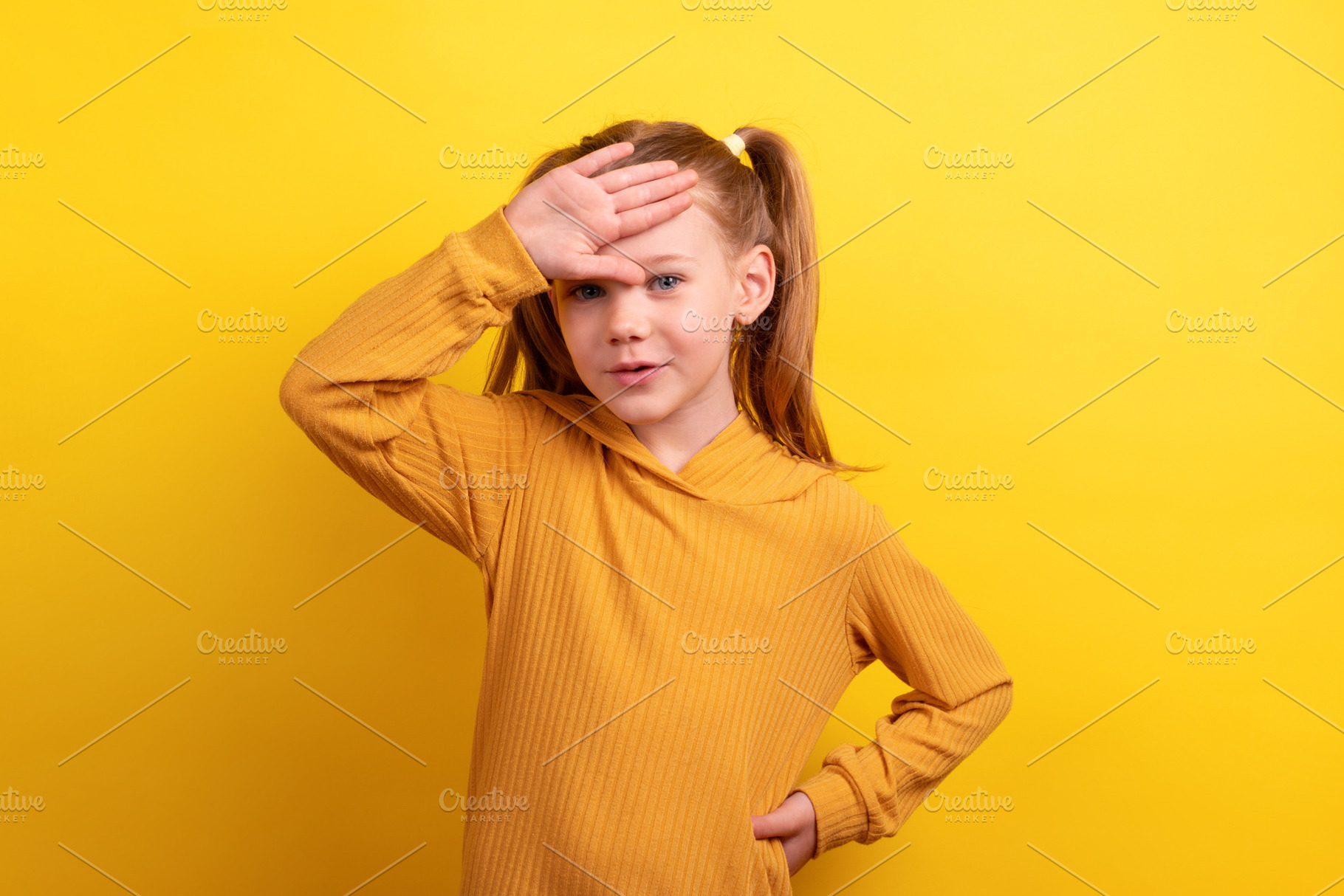 Young girl in mustard sweater with hand on her forehead, posing, a Person Photo by Ales Munt
