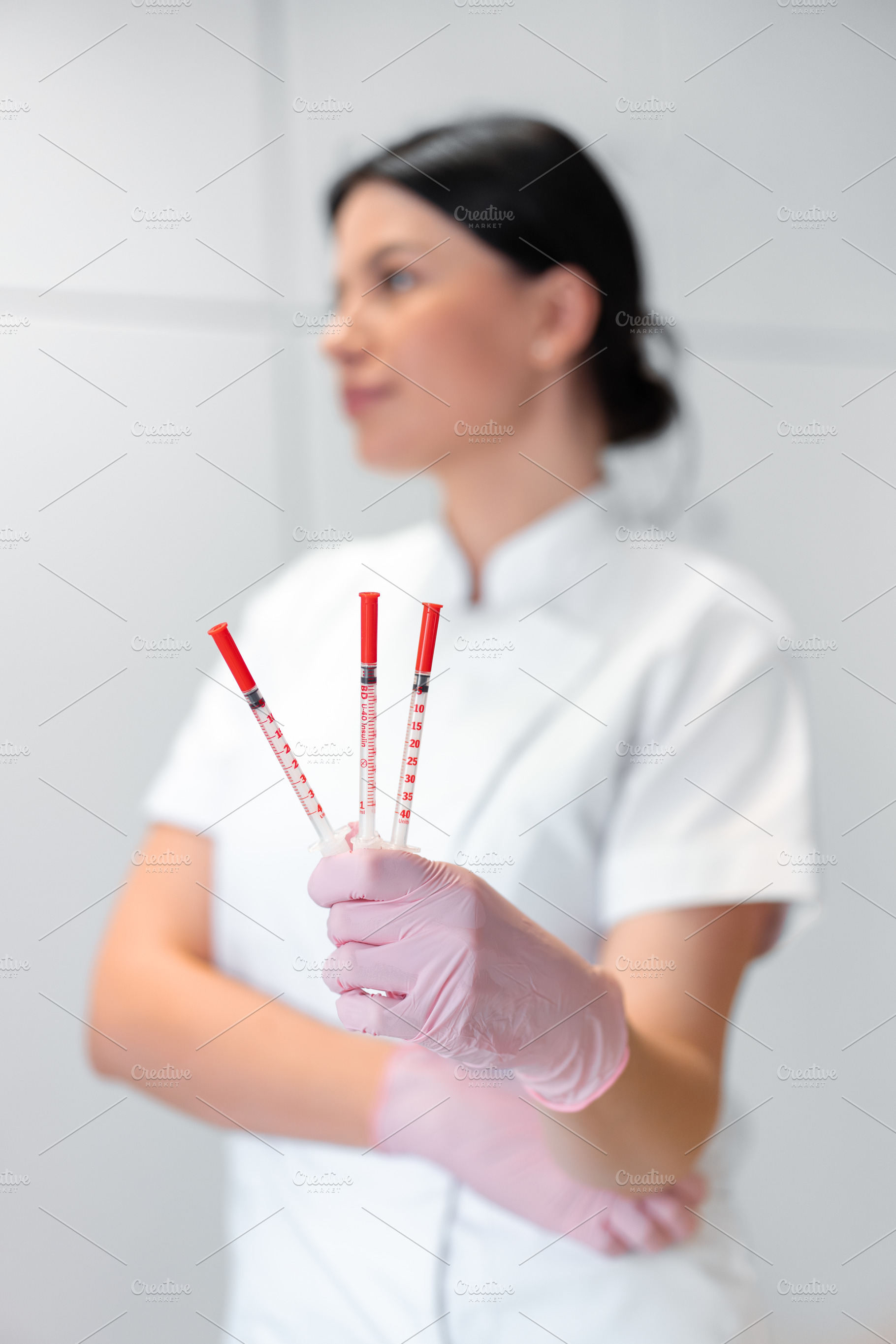 Female cosmetologist holding injection syringes in beauty clinic, a Photo by andreonegin market