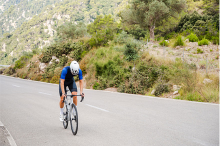 Unrecognizable cyclist climbing a, a Sports & Recreation Photo by Xavi Bosch Stock