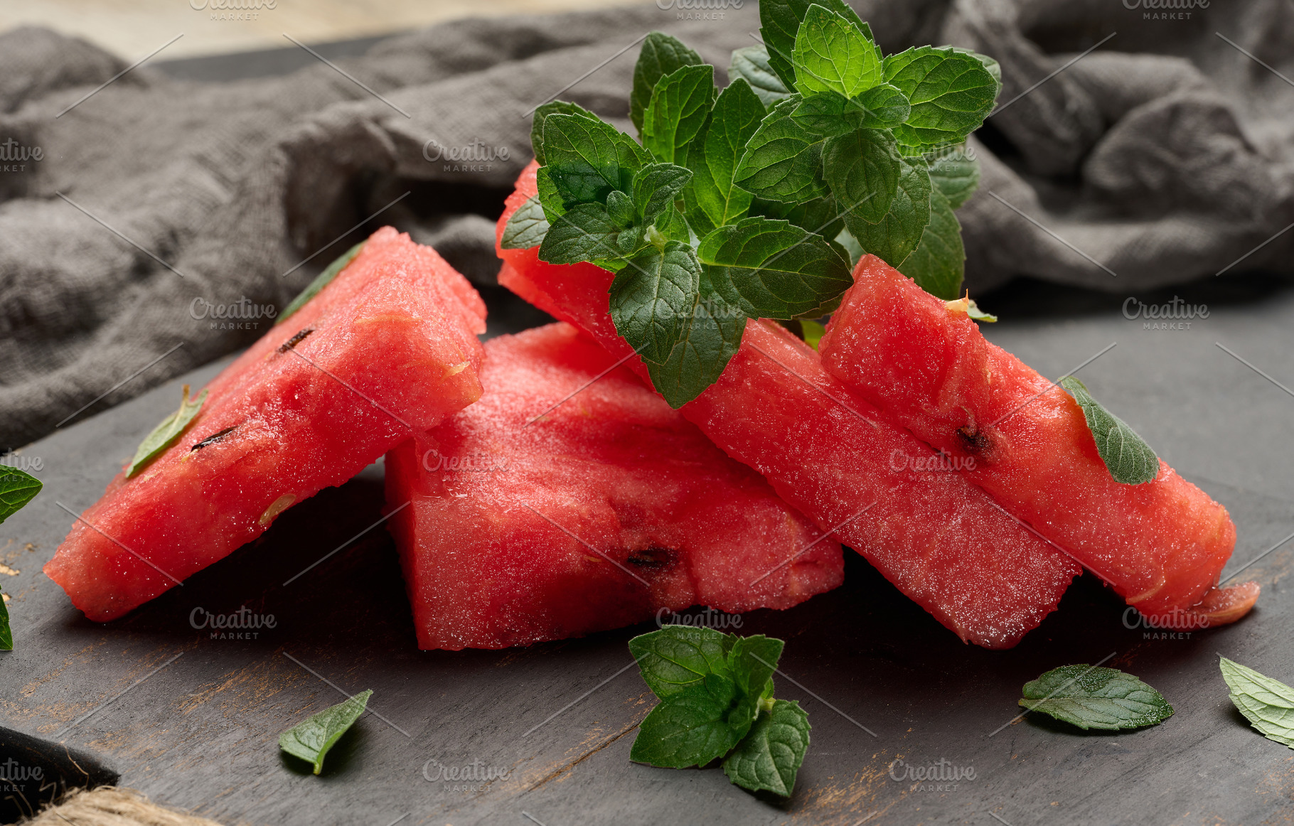 Fresh watermelon sliced into triangles with mint leaves on, a Food & Drink Photo by ndanko