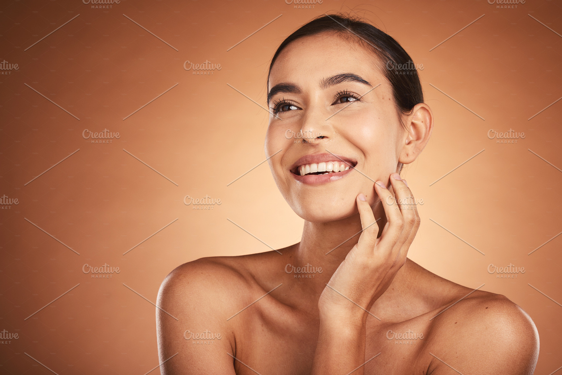 Thinking, beauty and skincare of hispanic woman against a brown studio background. Clean, smooth face skin of a happy woman after cosmetology and dermatology treatment for health and wellness, a Photo by Peopleimages.com