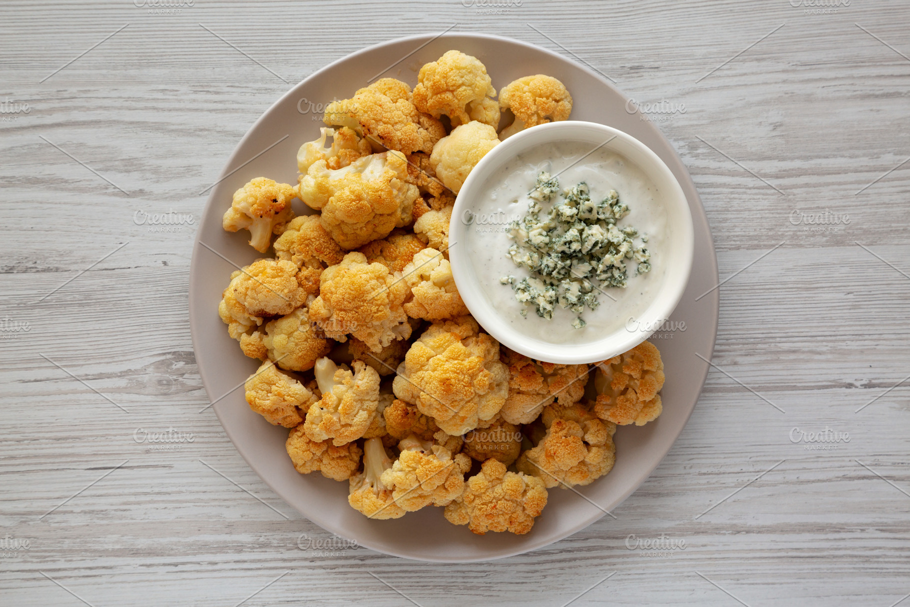 Homemade Buffalo Cauliflower with Blue Cheese Sauce, top view., a Food & Drink Photo by LiudmylaChuhunova