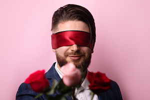 Smiling man in suit blindfolded with red ribbon, standing behind, a Person Photo by Ales Munt