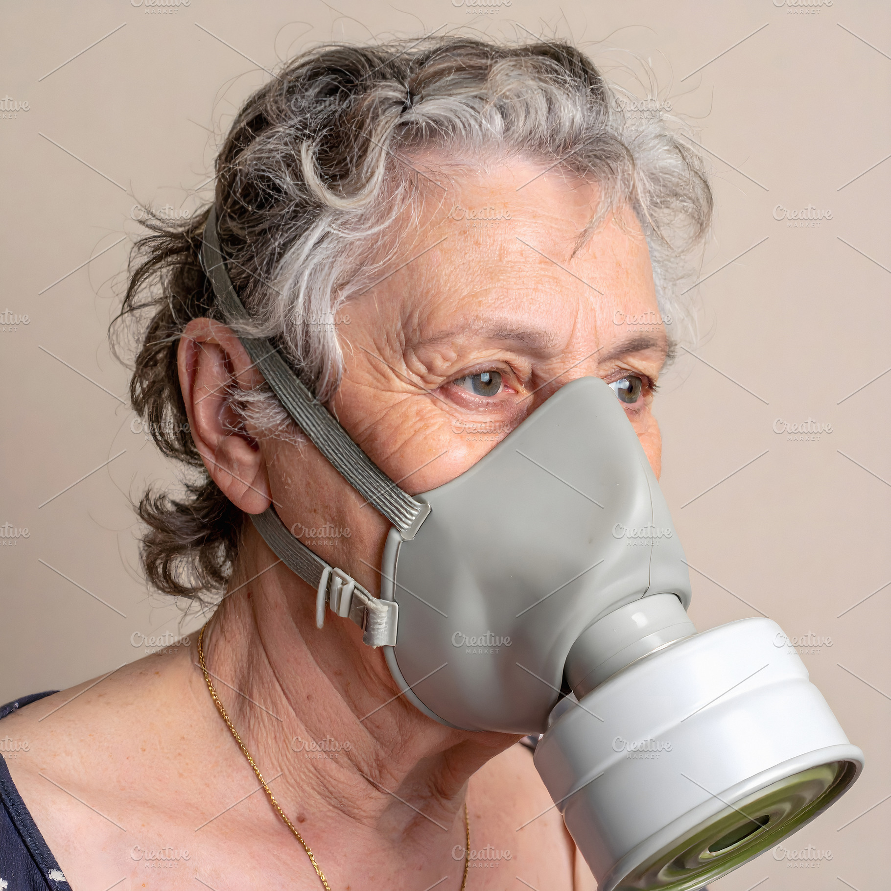 Elderly woman wearing gray gas mask indoors, a Person Photo by GoodGoods