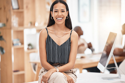 Smile, happy and business woman, desk portrait at work with blurred background. Leadership, motivation and smiling manager, leader or employee sitting with success, vision and confidence in office, a Photo by Peopleimages.com