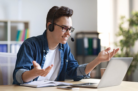 Online Meeting. Man in headset making video conference via laptop in office