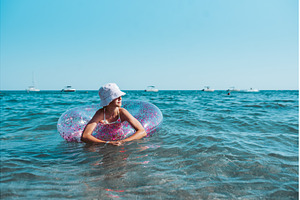 Girl on beach with swim ring during, a Sports & Recreation Photo by HalfPoint
